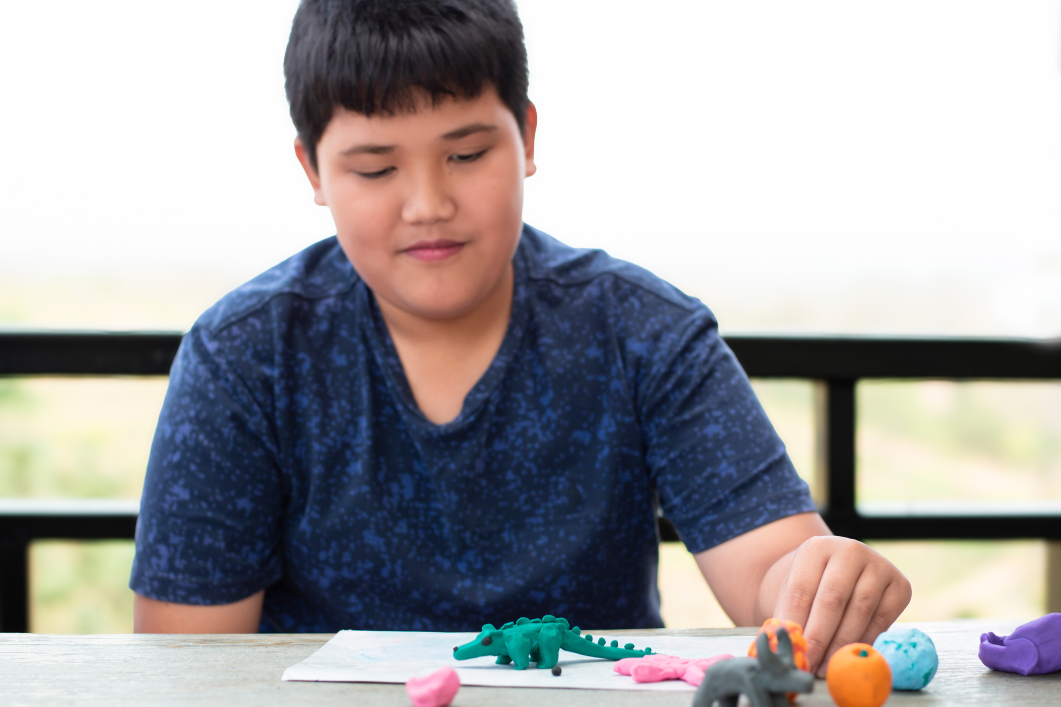 Young child with learning disability practicing plasticine shapes